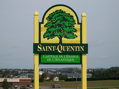 Grand panneau jaune avec un arbre vert et les mots "Saint-Quentin, Capitale de l'Érable de l'Atlantique".
