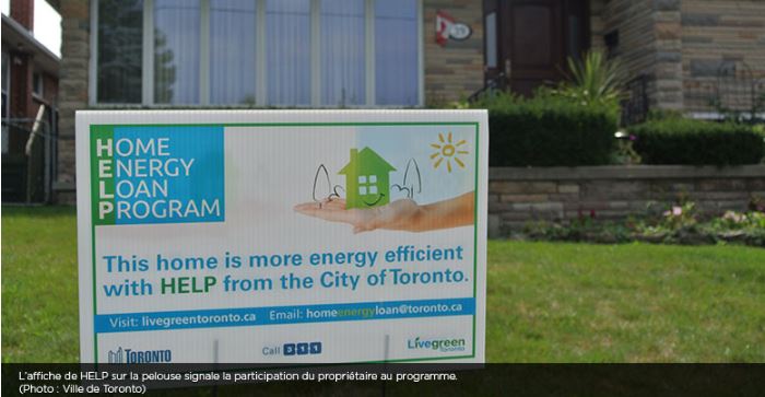 Panneau du programme de prêts pour des rénovations écoénergétiques pour des maisons sur une pelouse à Toronto, en Ontario où on peut lire : « Cette maison est plus écoénergétique grâce au programme HELP de la Ville de Toronto » 