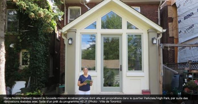 Femme ayant reçu un prêt du programme de prêts pour des rénovations écoénergétiques de maisons debout devant sa maison, à Toronto, en Ontario