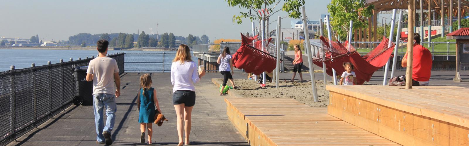 A young family walks along the pier in New Westminster Park